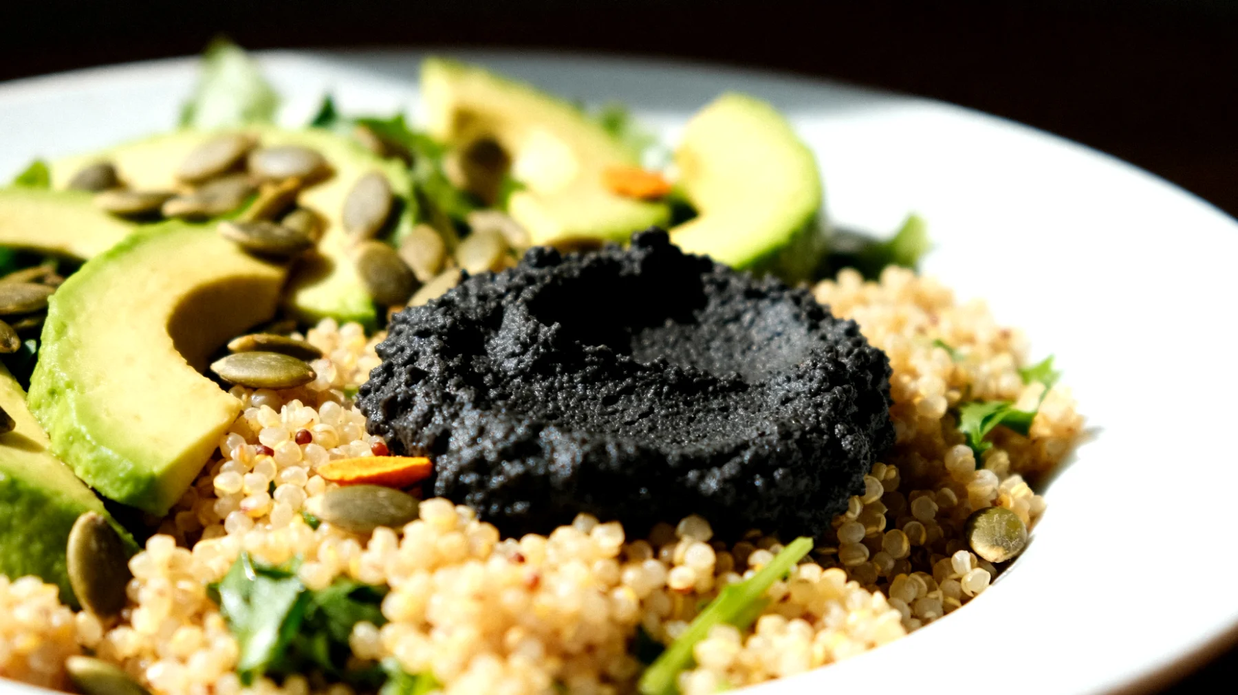 Insalata di miglio con hummus di ceci neri, avocado e semi di zucca"