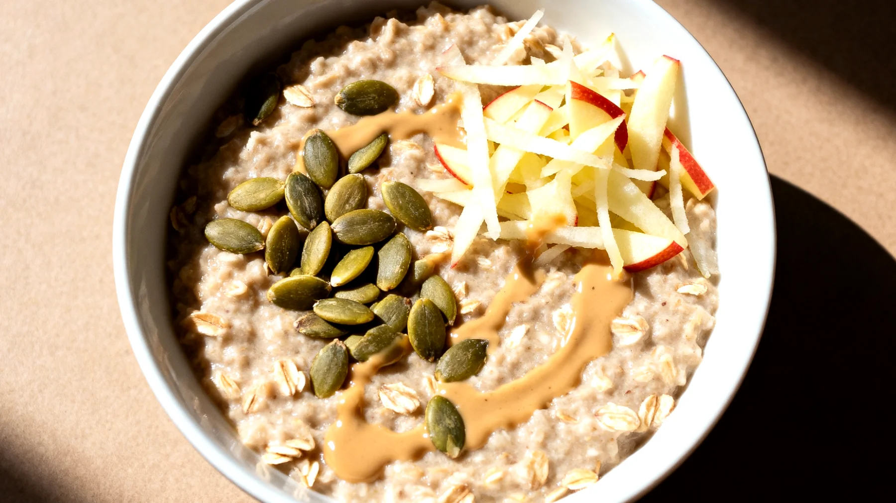 Porridge di avena con semi di zucca, tahini e mela grattugiata"